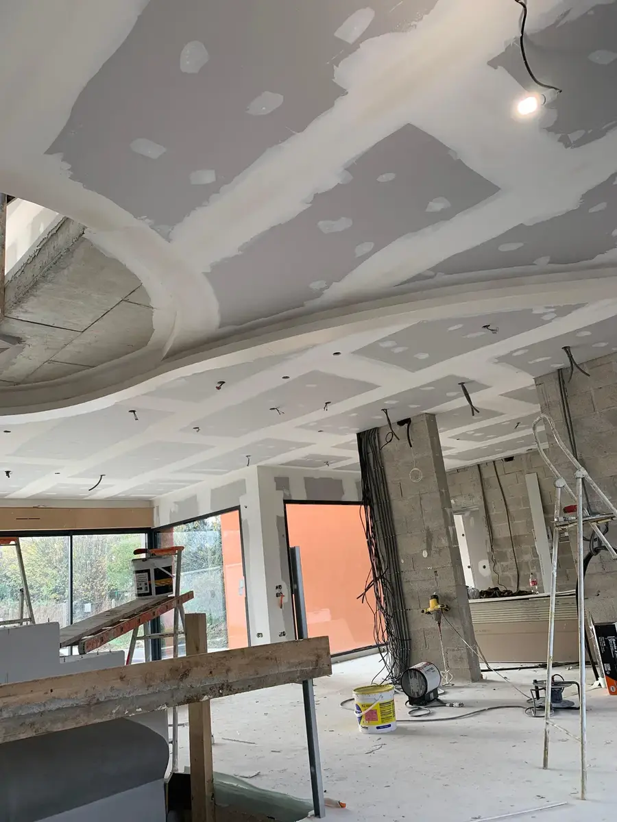 Intérieur contemporain avec faux-plafond et grandes baies vitrées