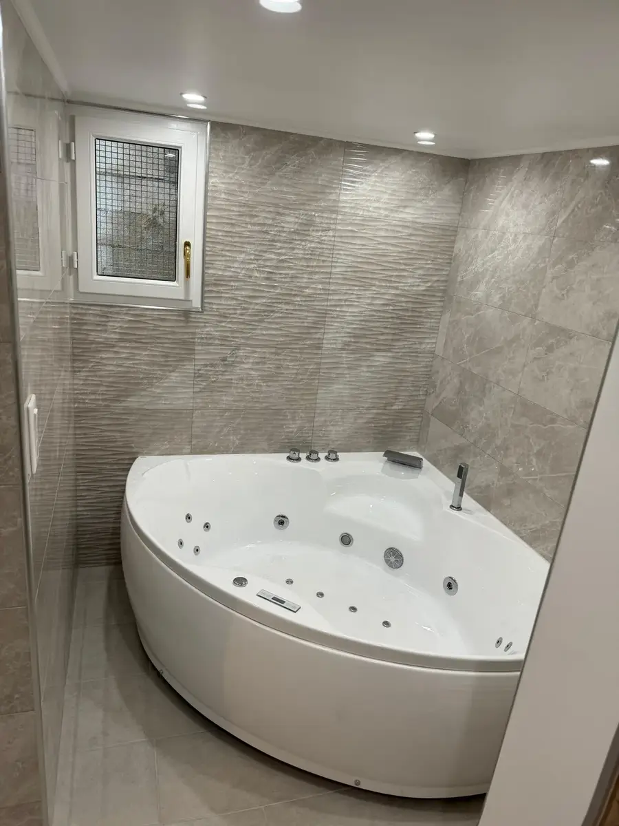 Salle de bain avec baignoire balnéo et douche à l'italienne